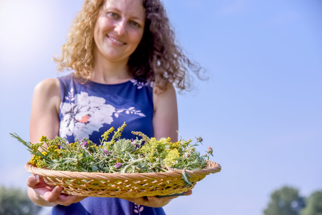 Elisabeth Teufner mit einem Korb voller frisch gesammelter Kräuter